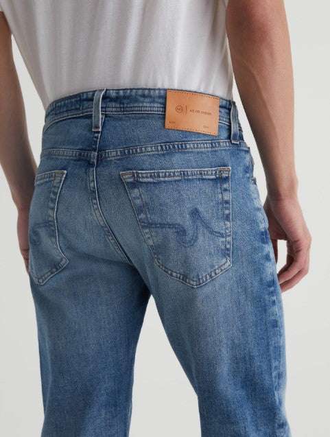 Light blue AG Tellis Aged Modern Slim Denim men's jeans with a tapered leg and 19-year fade