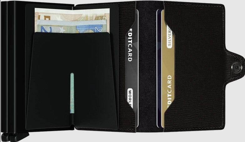 Secrid Twinwallet black leather wallet with dual card protectors, holding multiple cards and banknotes.
