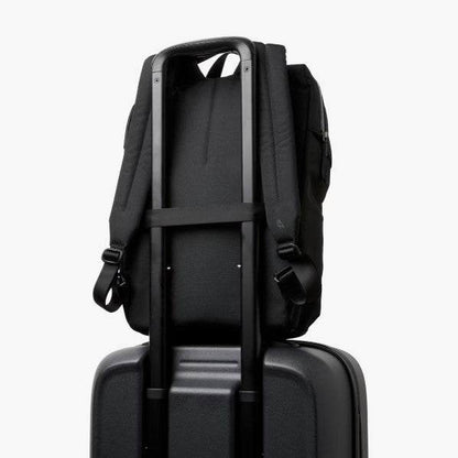 Black Bellroy Via Workpack backpack with padded straps mounted on suitcase handle for easy travel